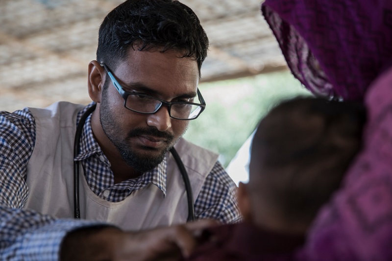 Mohammadh Abdul Kader examines a child at the Sabrang entry point in Teknaf subdistrict. Photo: Anna Surinyach