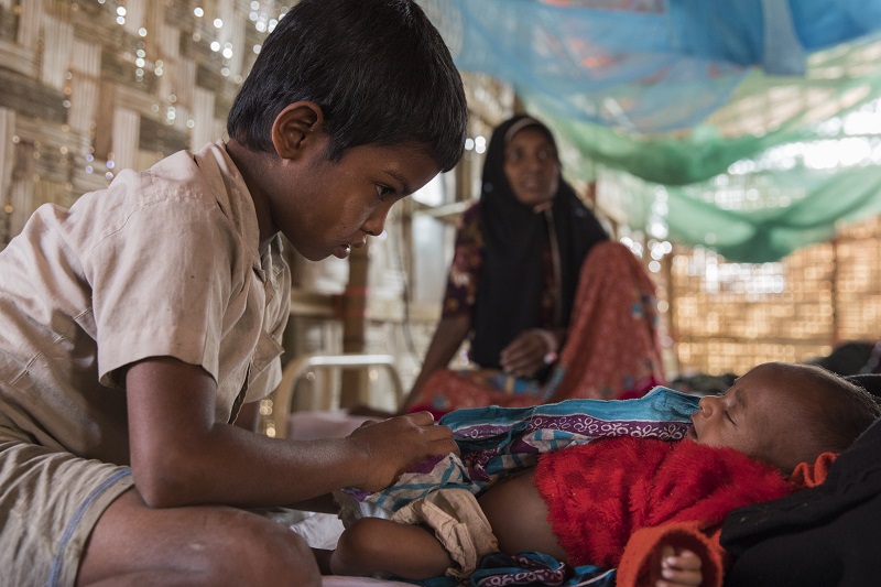 Muhamed Faisal cares for his little sister, Ruzina. Photo: Anna Surinyach
