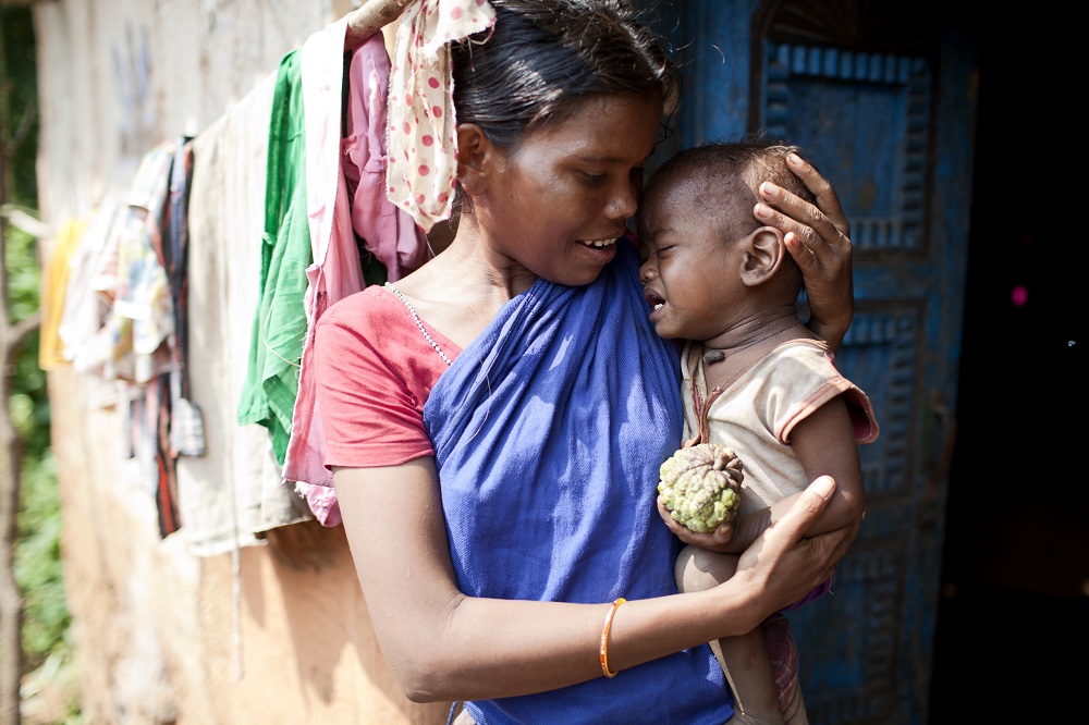 Joma Samad comforts here malnourished infant Budu Samad in remote, hilly and forested Bharania.
