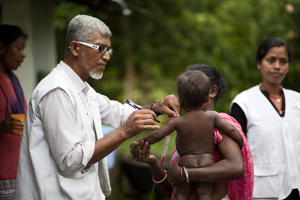 An MSF health worker measures a child with a MUAC tape for symptoms of malnutrition at an ATFC in Chakradharpur, Jharkhand.