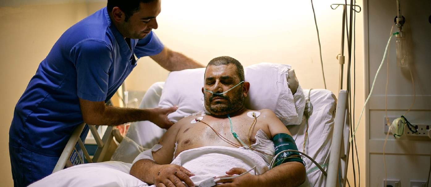A Syrian patient is helped by an MSF medical staff in Ramtha Hospital, at the border between Syria and Jordan. Photo: Denis Bosnic