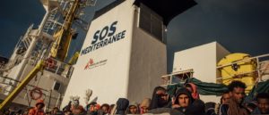 Men, women and, children rescued at sea by crews of the MV Aquarius, jointly operated by MSF and SOS Mediterranee, look out as the ship approaches land in Italy, 30 December 2016. Photo: Kevin McElvaney