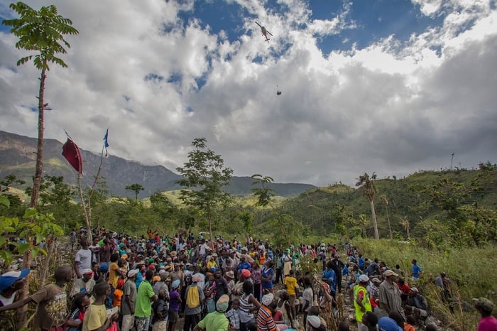 Residents of Bolosse, in the Haitian mountains, watch the arrival by helicopter of an MSF relief package of medical aid and building materials. MSF is conducting relief distributions in some of the most remote areas of the country following the devastation by Hurricane Matthew.