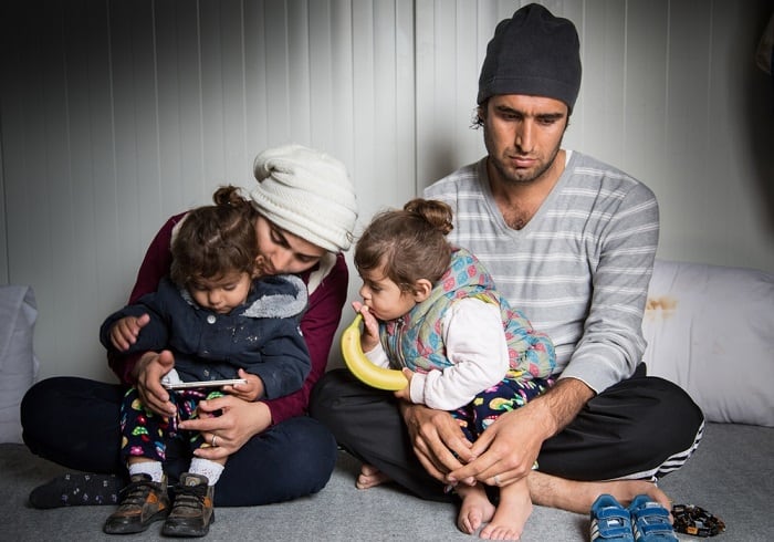 Karon, 31, sits with his wife and their twin girls in a refugee shelter on the Greek island of Lesvos. The family arrived in August 2016 but have since been blocked by Greek authorities from leaving the island to continue their journey to the mainland.