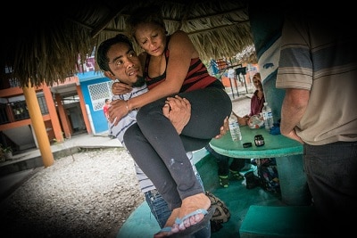 William carries Gloria to the police station where they will report a violent assault, suffered on the route from the Guatemalan border into Mexico. Both Gloria and William had to leave Honduras because of death threats from maras (local gangs).