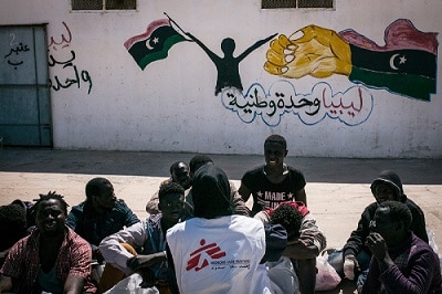 MSF staff member talks to men detained in Abu Salim detention centre, in Tripoli, Libya.
