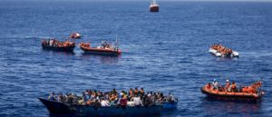 Wooden boats filled with people are rescued by MSF Vos Prudence in the sea off the coast of Libya, on June 9, 2017. Photo: Andrew McConnell/Panos Pictures