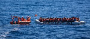 Lifejackets are distributed to 129 people in a rubber boat by an MSF rib in international waters off the north coast of Libya, on June 8, 2017. Photo: Andrew McConnell/Panos Pictures