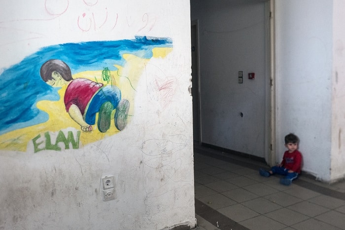 A young boy sits in a corridor of an abandoned spa resort in Thermopylae, Greece. The resort buildings are being used to house refugees where MSF is providing mental health care to those that find themselves trapped there by EU refugee policy preventing them from continuing their journey through Europe.