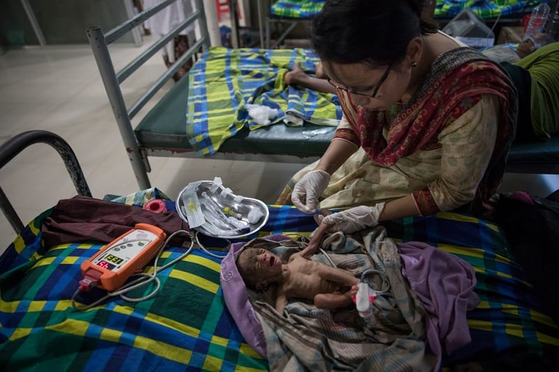A severely malnourished and premature 15-day-old baby receives treatment in the pediatric - neonatal unit at MSF's medical facility in Kutupalong. Photo: Paula Bronstein/Getty Images
