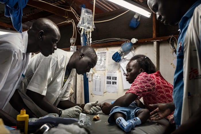August 2017 – Doctors examine seven-month-old Bless, at the MSF hospital in Aweil, South Sudan. Bakhita (R), who is an MSF midwife in the same hospital, brought her son in suspecting he has malaria.