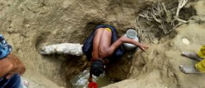 A man scoops water from a hand-dug well in Unchiparang makeshift settlement, home to 33,000 of the half a million Rohingya refugees who have fled violence in Myanmar since the end of August 2017. Photo: Paul Andrew Jawor/MSF