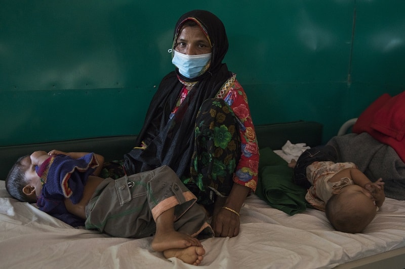 Chalima Khatun, a 30-year-old Rohingya woman, sits with two of her children in a ward of MSF’s Diphtheria Treatment Centre in Moynarghona. Photo: Anna Surinyach