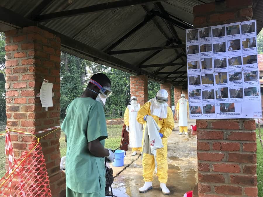 MSF staff in protective equipment are disinfected at Bikoro ETC. Photo: Louise Annaud/MSF