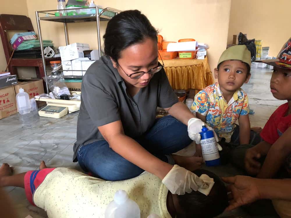 Dr Rangi Wirantika dressing the wound of a four-year-old boy named Adam. His head was wounded as he fled during the earthquake and tsunami that hit Indonesia's Sulawesi island on 28 September 2018.