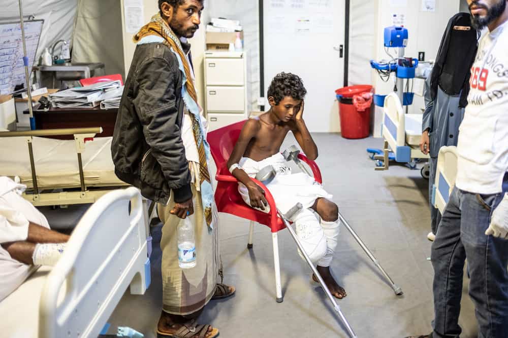 Nasser (centre) and his father Mohammed (left) in one of the inpatient wards at MSF’s surgical hospital in Mocha. AGNES VARRAINE-LECA/MSF