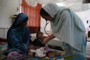 An MSF physician examines a malnourished child in the inpatient therapeutic feeding centre in the Dera Murad Jamali District Headquarter Hospital in eastern Balochistan, Pakistan.  &copy;P.K. Lee/MSF
