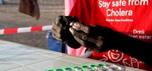 An MSF team member prepares an oral cholera vaccine. © Corinne Baker/MSF