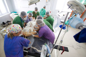 MSF staff transfer a severely injured patient to the operating table at MSF Kunduz Trauma Center.