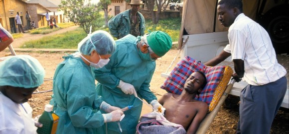 MSF staff treat a patient with bullet wounds at Rwanda's Nianza hospital in July 1994. © Roger Job