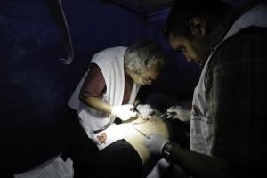 Steve Rubin tends to a patient with shrapnel wounds. Syria 2013 © Robin Meldrum/MSF