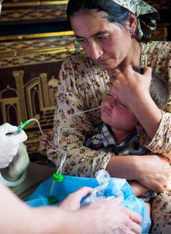 A medical nurse performs nasopharyngeal aspiration on a 2-year-old boy, suspected of having MDR-TB. &copy; Wendy Marijnissen