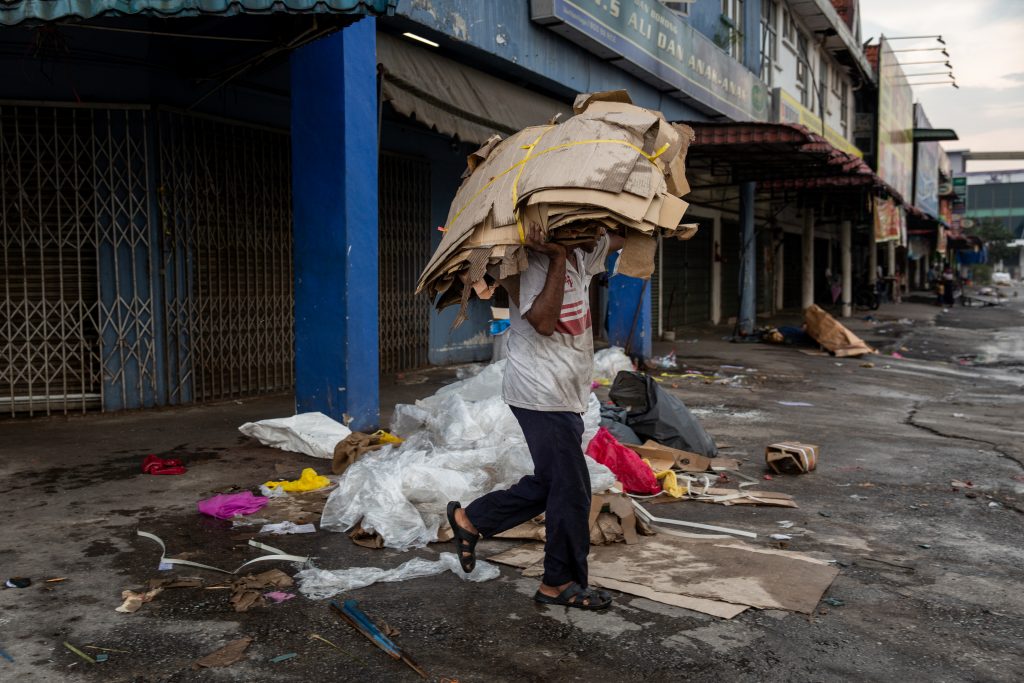 A Rohingya man collects cardboard and plastic, which will then be sold by the kilo. Pasar Baur market, Kuala Lumpur, April 2019. © ARNAUD FINISTRE