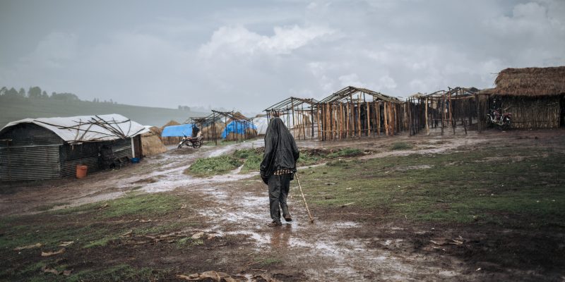 A man walks in the rain in Rho camp, DRC, November 2019. © ALEXIS HUGUET