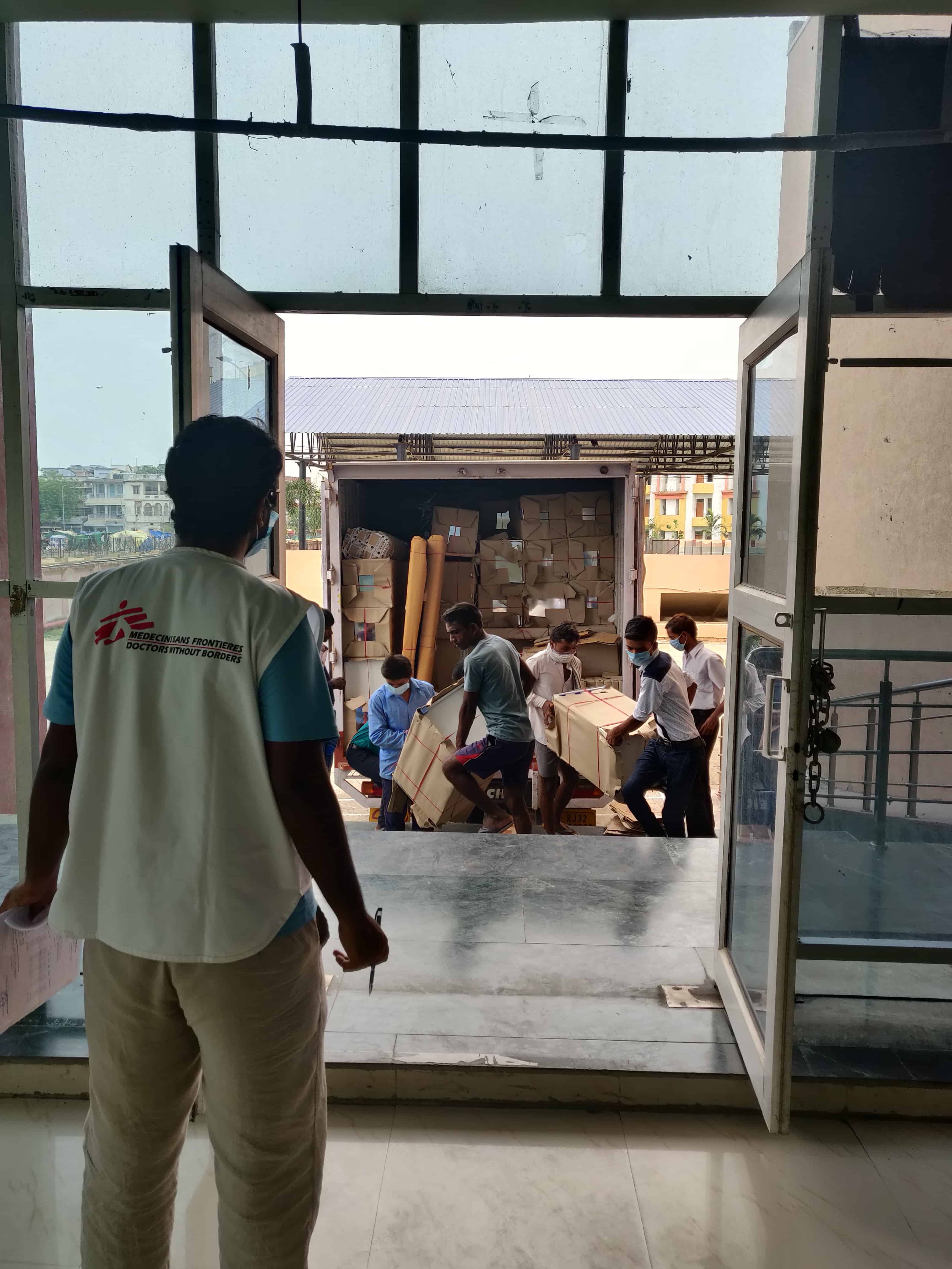 The Logistics team unloading the required material, including beds and PPEs for the MSF's 100-bed COVID treatment facility at Patliputra sports complex, Patna. ©MSF