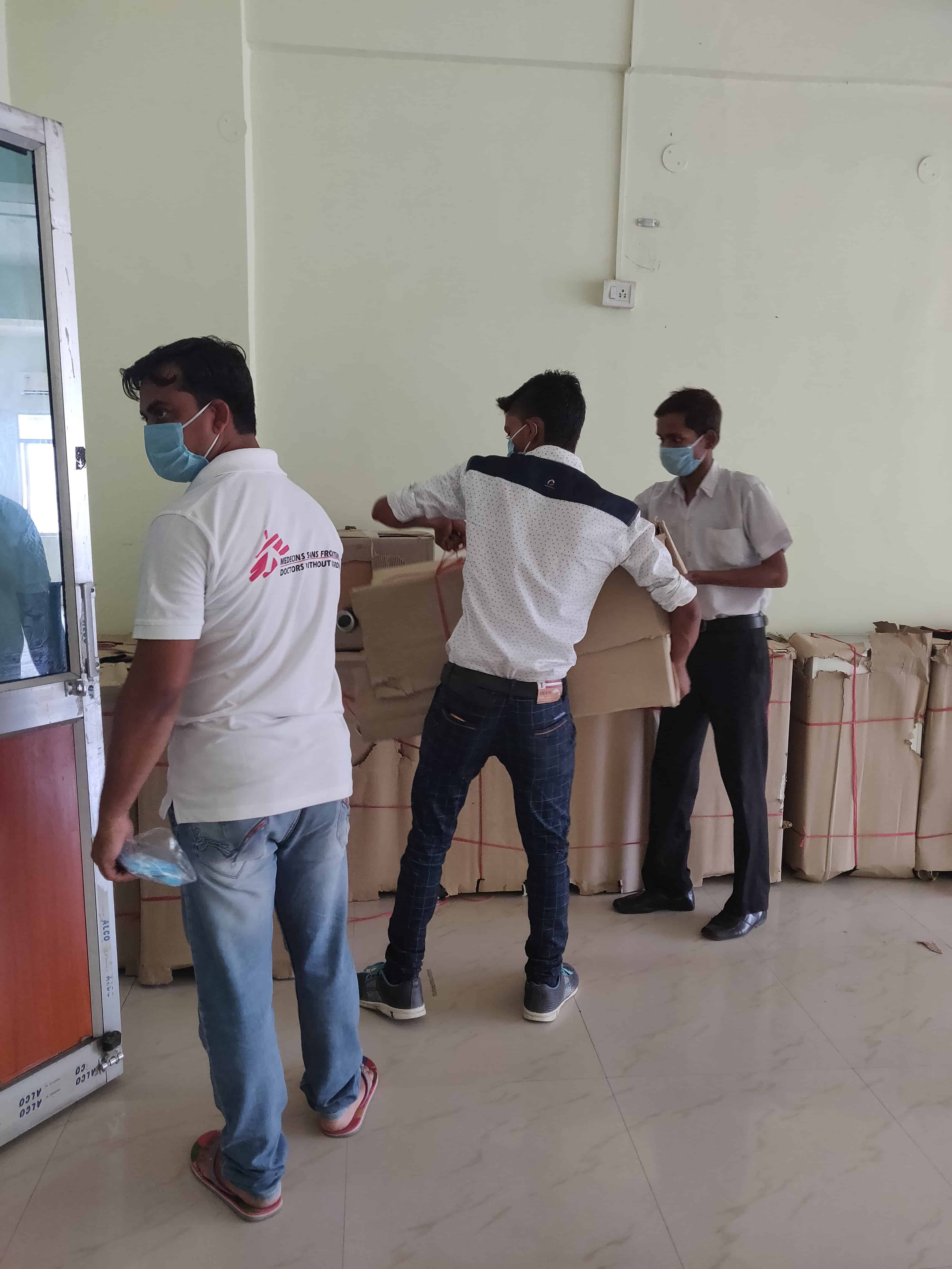 The Logistics team unloading the required material, including beds and PPEs for the MSF's 100-bed COVID treatment facility at Patliputra sports complex, Patna. ©MSF