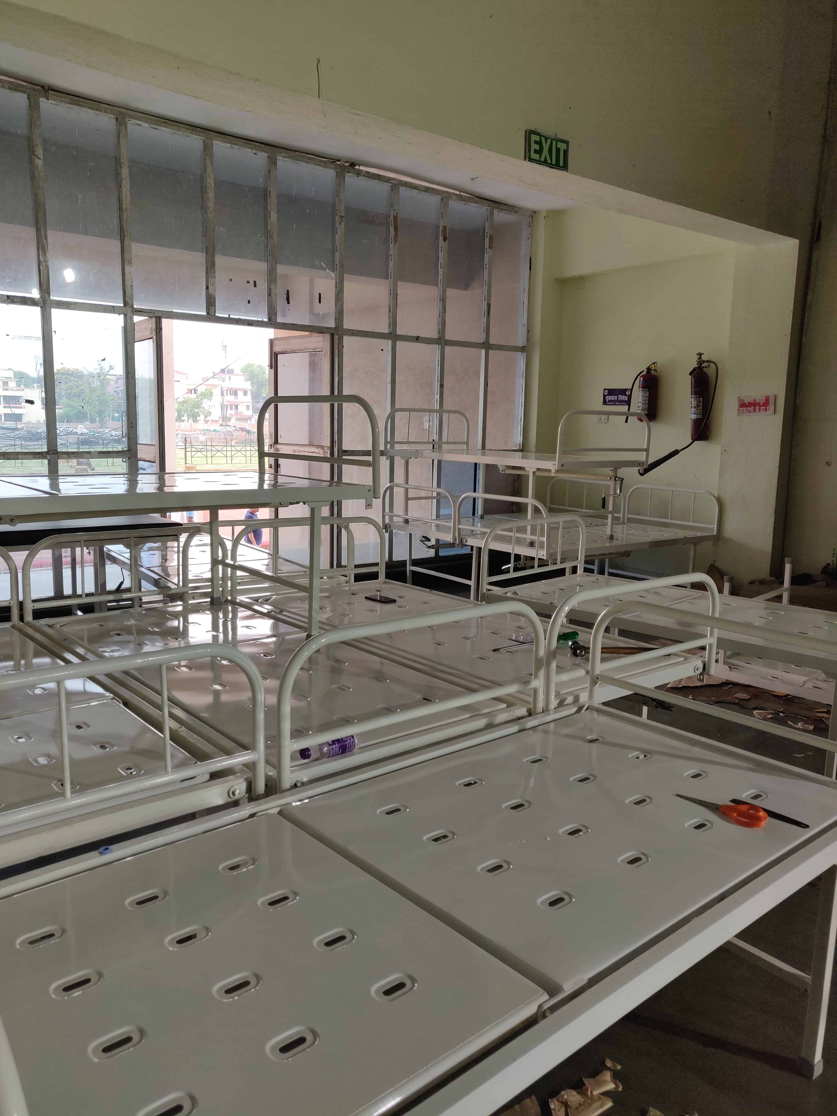 Patient beds assembled and lined up in the storage area of the indoor stadium of Patliputra Sports Complex, Patna, Bihar. This complex will be converted into a 100-bed treatment facility for COVID - 19 patients. ©MSF
