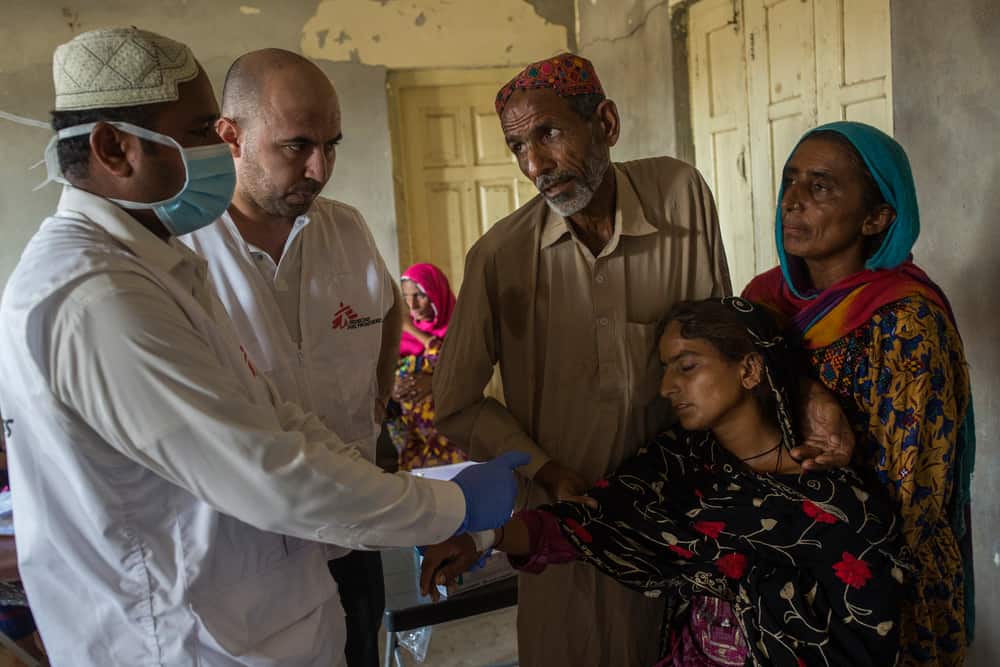 Siddiq, a male nurse, gives medical assistance to flood-affected woman Mumtaz, 22, who is suffering from high fever at MSF's mobile clinic in village Ghulam Muhammad Lashari in Thul town Ghulam Muhammad Lashari village of Thul town of Jacobabad District in the Sindh Province of Pakistan on 26th October 2022.