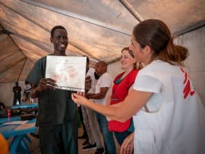 MSF Head of Mission hands a certificate to one of the nursing students at the MSF Academy graduation ceremony in Old Fangak.