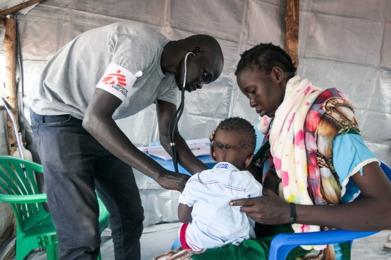 MSF Clinical Officer Chuol Hoth examines a child at the MSF Mobile Clinic in Bulukat transit centre, Upper Nile State South Sudan.  

The Bulukat transit centre hosts thousands of returnees living under temporary shelters. Their living conditions are deplorable as the now muddy terrain heightens their life with onset of diseases