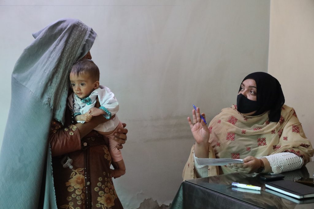 MSF Health Promotion Supervisor Razia is guiding a woman about medication. The woman came to Kuchlak Mother and Child Healthcare facility to have her one-year-old son checked.