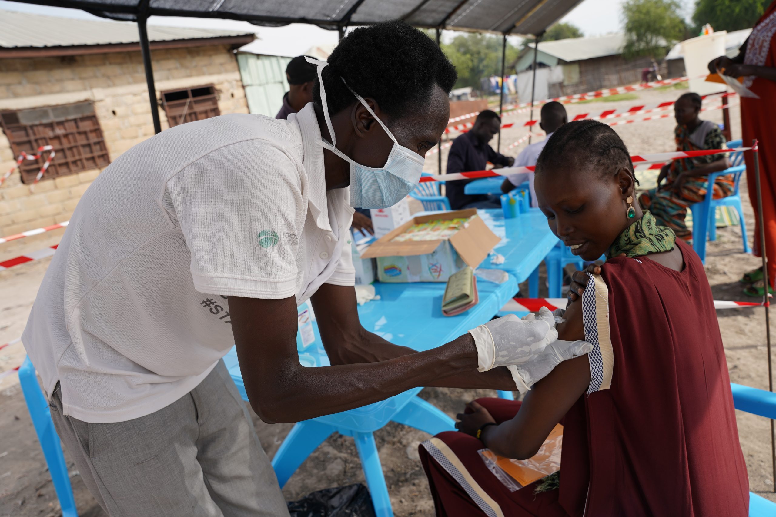 An MSF vaccinator administers the hepatitis E vaccine to a woman in Hai Matar, Fangak County, in the first round of the campaign in December 2023. © Gale Julius Dada/MSF