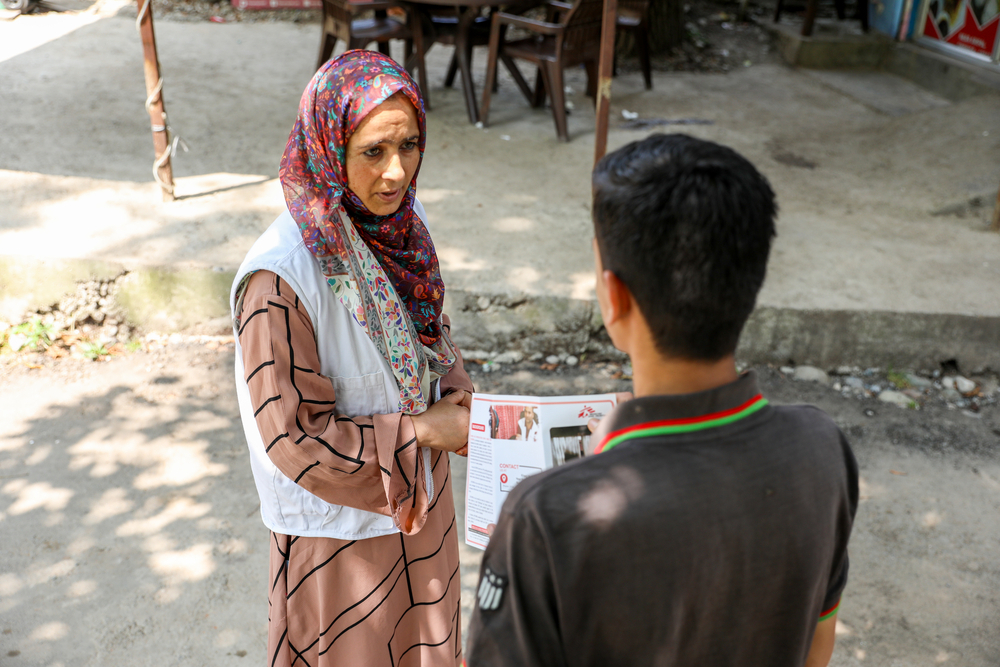 Shameema Rashid, Doctors Without Borders India/Médecins Sans Frontières (MSF) community mental health worker, speaks with local residents during an outreach session in Tral area of Baramulla district, Kashmir. MSF health promotion teams provide information about mental health issues and available MSF support services to community members.