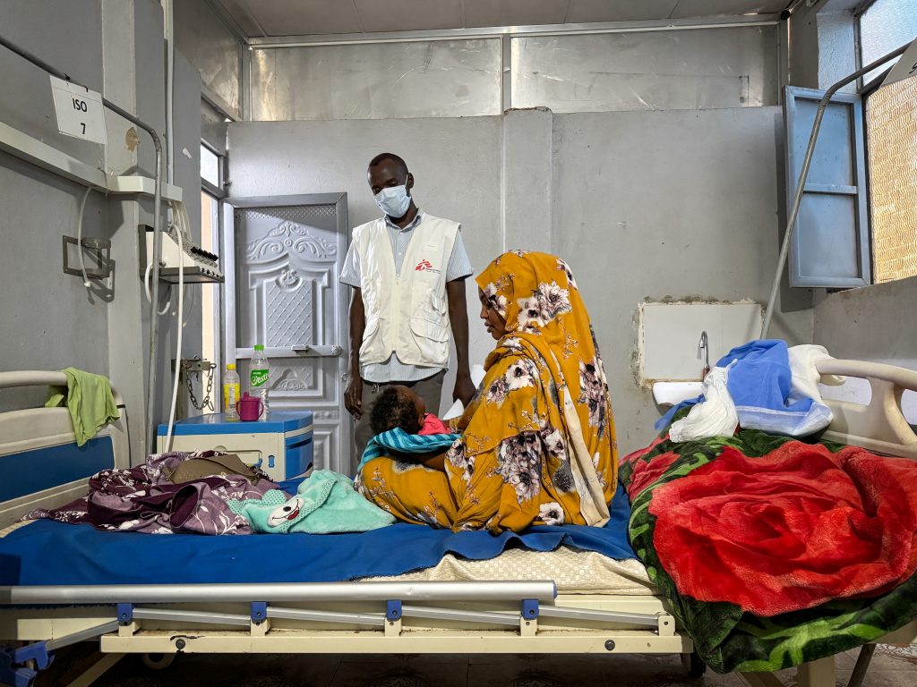 Ferdos holds her 11-month-old baby, Banan, who is infected with measles, in the isolation ward at El Geneina Teaching Hospital, supported by MSF. War forced Ferdos and her family to flee to El Geneina, where they live in overcrowded conditions with other families. Her son contracted measles and infected his 11-month-old daughter.