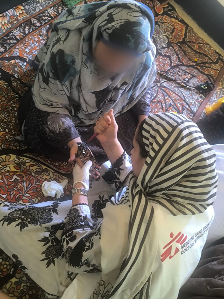 While applying henna (mehendi) to a community member's hand in Kashmir, a Doctors Without Borders India/Médecins Sans Frontières(MSF) community mental health worker uses the familiar ritual to open a quiet conversation about the impact of psychosocial activities on mental wellbeing and suicide prevention. ©MSF
