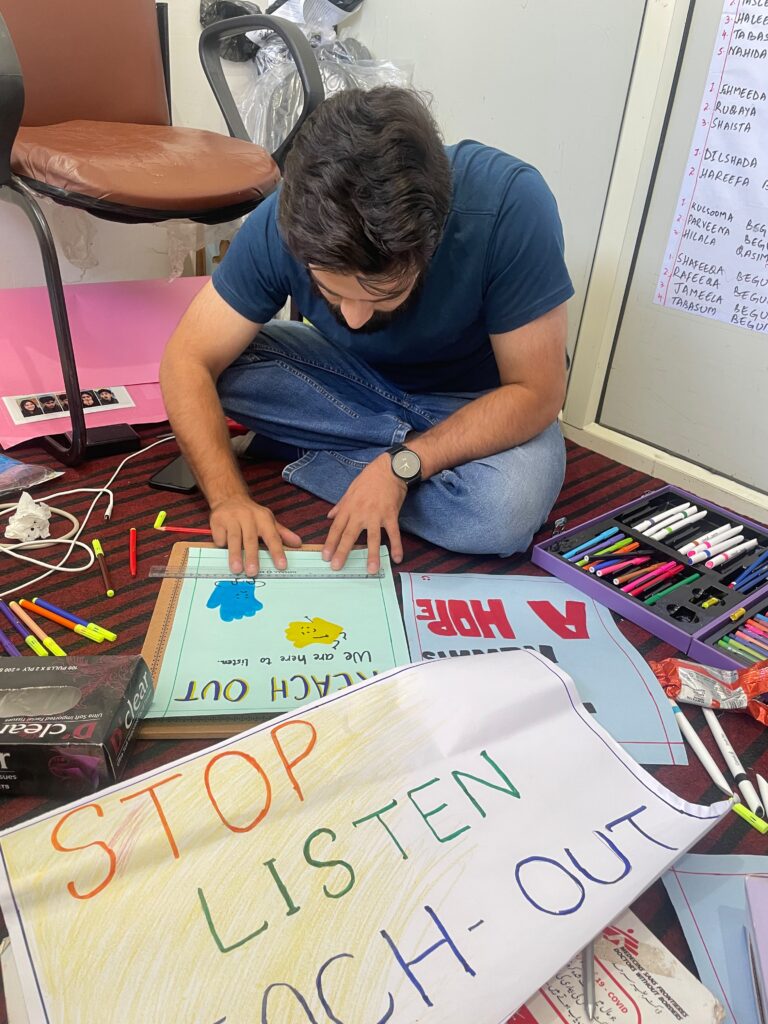 A Doctors Without Borders India/Médecins Sans Frontières(MSF) counsellor educator in Kashmir paints a "Stop. Listen. Reach Out." poster, one of several hand-made messages of support prepared for a World Suicide Prevention Day event. ©MSF